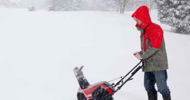 1592717 man using snow blower on snowy drive