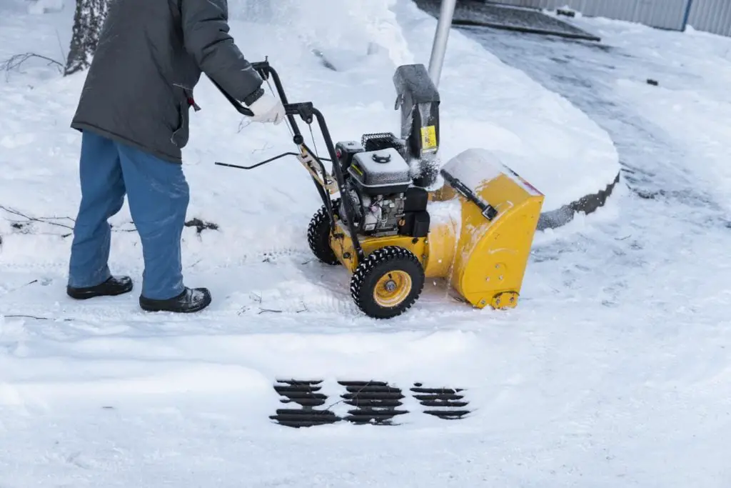 Man cleaning driveway with snow machines